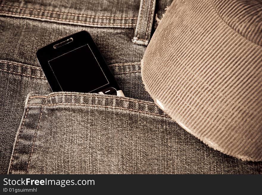 Grunge jeans with a mobile phone and worn baseball cap