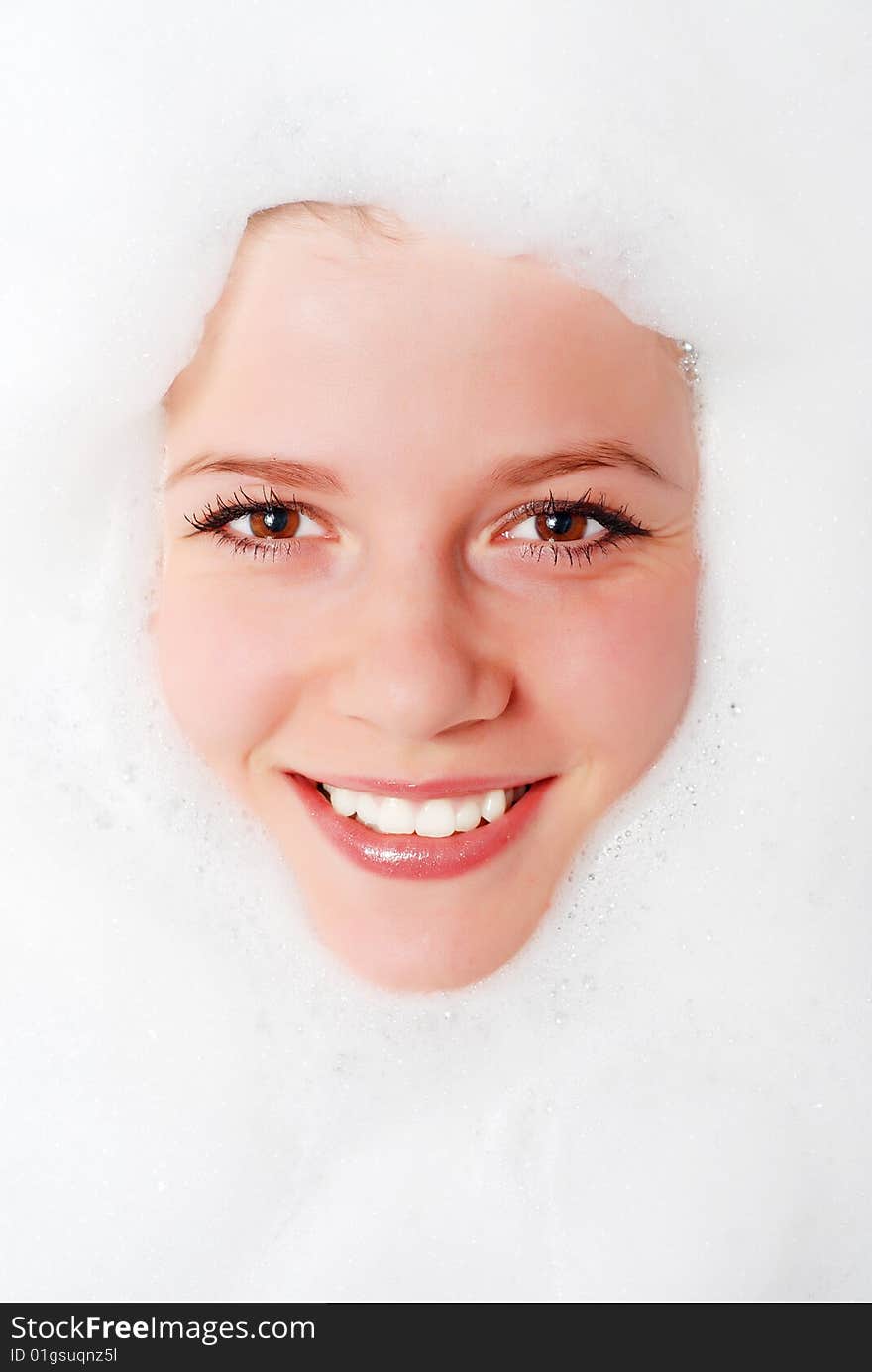 Face of a beautiful woman in white foam. Face of a beautiful woman in white foam