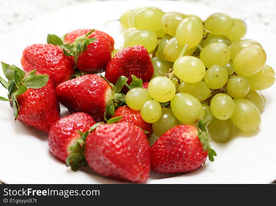 Grape and strawberry over white dish isolated