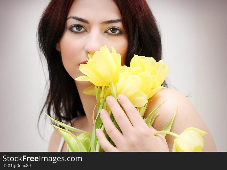 Oriental pretty girl with yellow tulips. Oriental pretty girl with yellow tulips