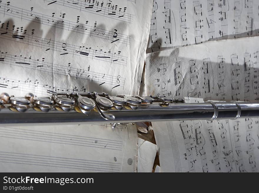 Western concert flute with a old sheet music. Western concert flute with a old sheet music