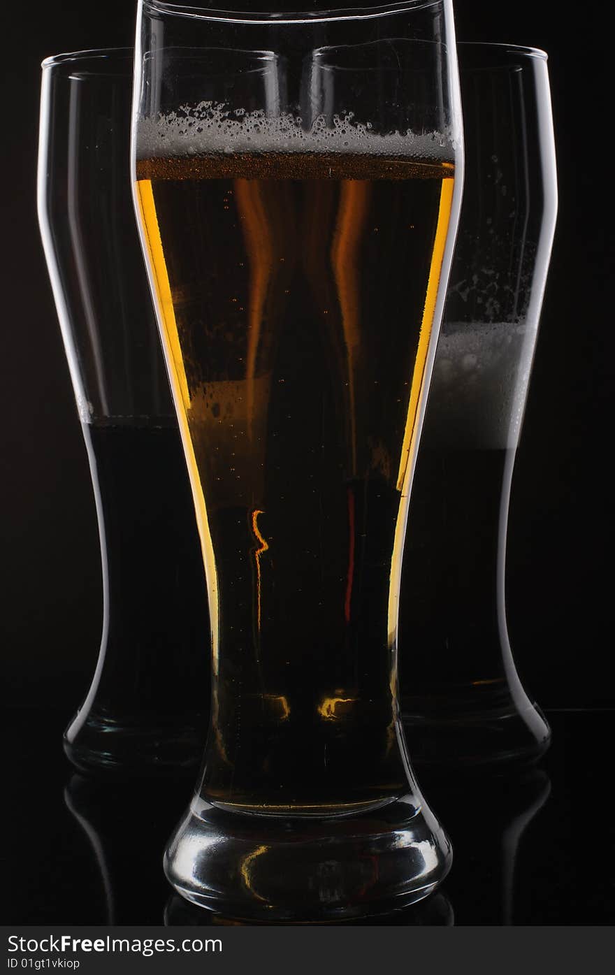 Three glasses with light and dark beer. Three glasses with light and dark beer