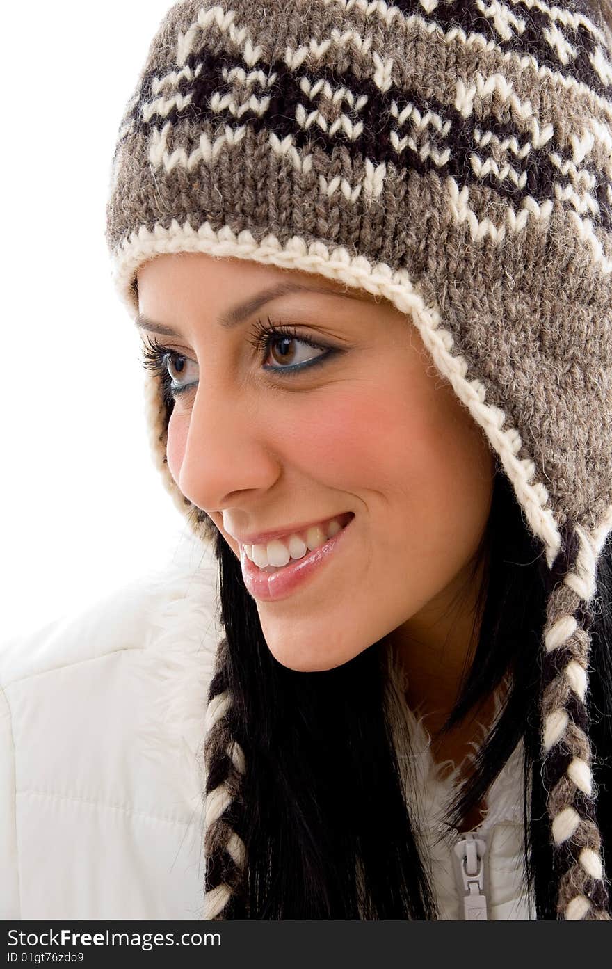 Side pose of smiling woman wearing woolen cap against white background