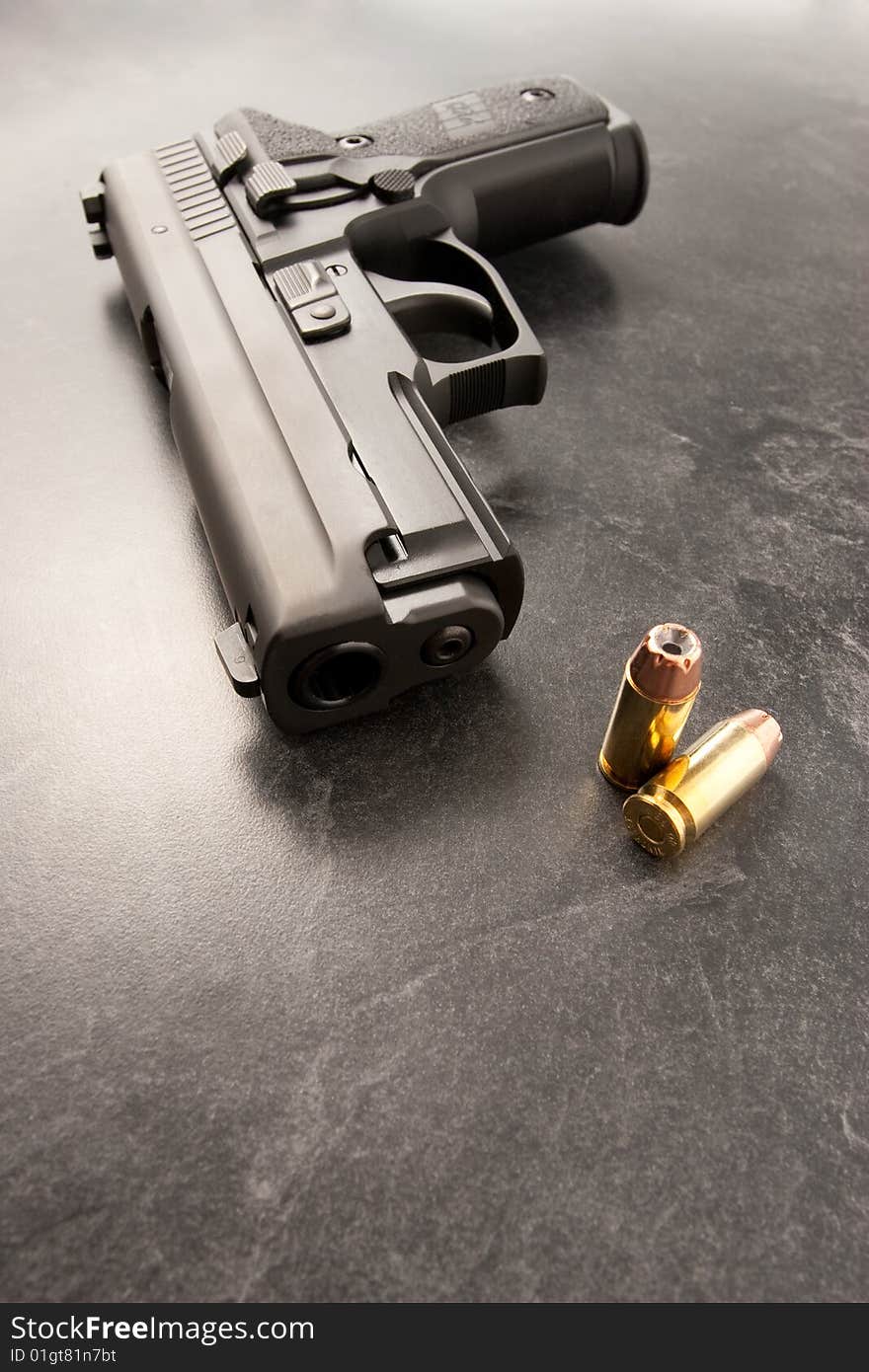 Wide angle of handgun with muzzle and two hollow point bullets. Wide angle of handgun with muzzle and two hollow point bullets.