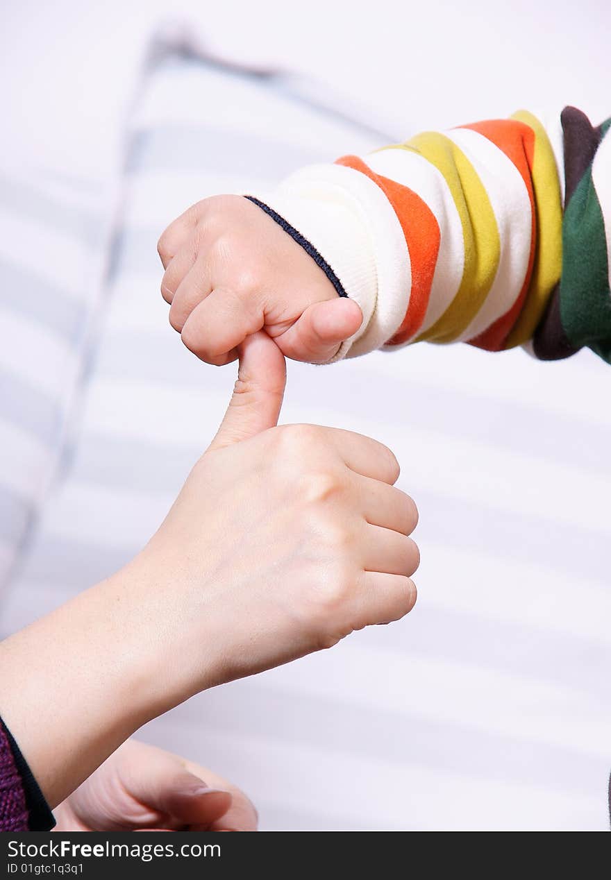 A picture of hands of a mother and child playing games together. A picture of hands of a mother and child playing games together