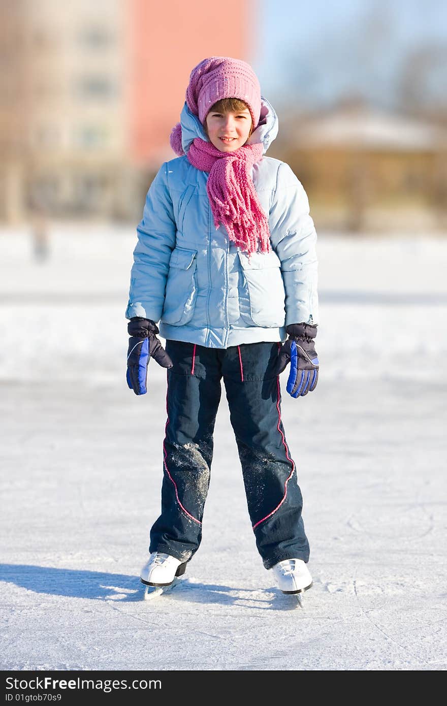 Girl on skates at the skating rink in winter.