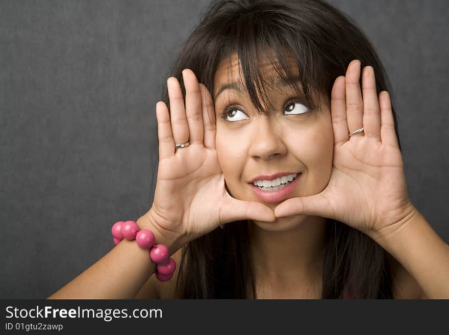 Beautiful young woman framing her face with hands