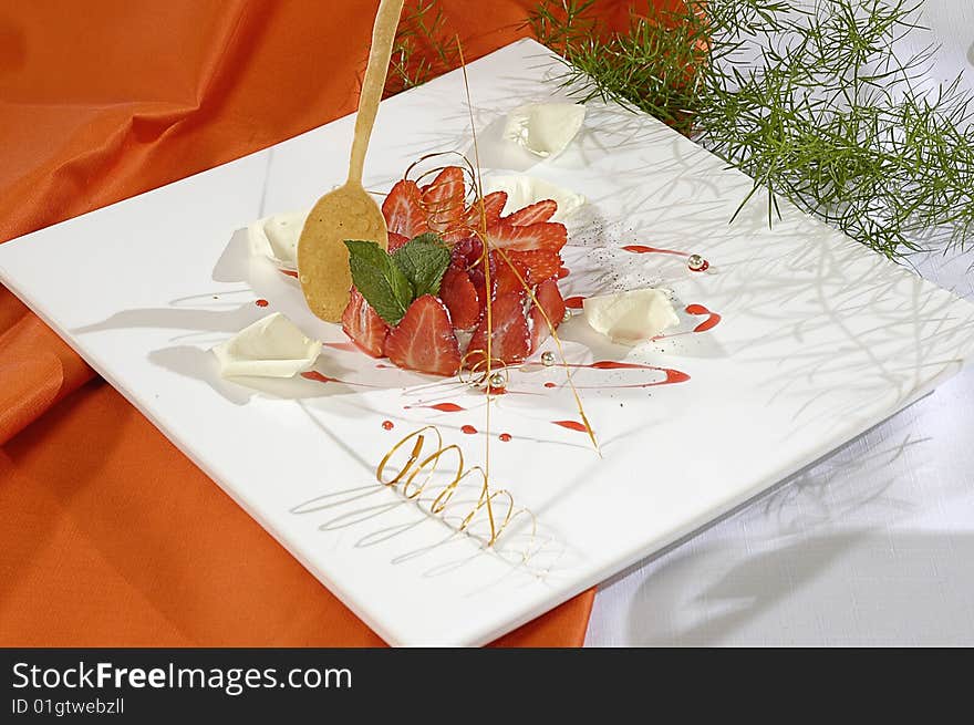 Strawberry dessert, decorated white petals of rose, pearls and mint