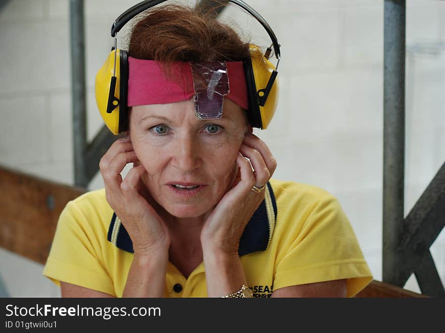 Female competitor at shooting range waiting for other participants to shoot