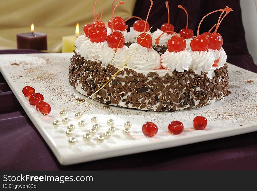 Cream cake, decorated the red sweet cherry