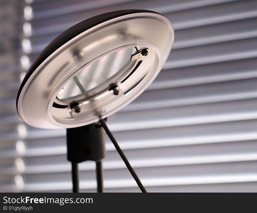 Desk lamp taken against morning light through a venetian blind. Desk lamp taken against morning light through a venetian blind