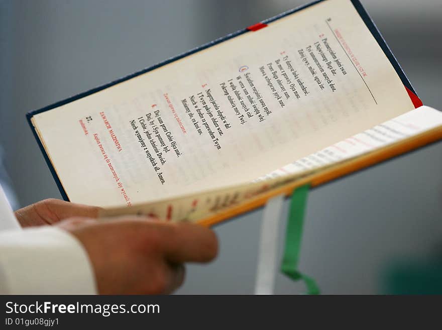 Priest reading open holly bible, wedding in Poland