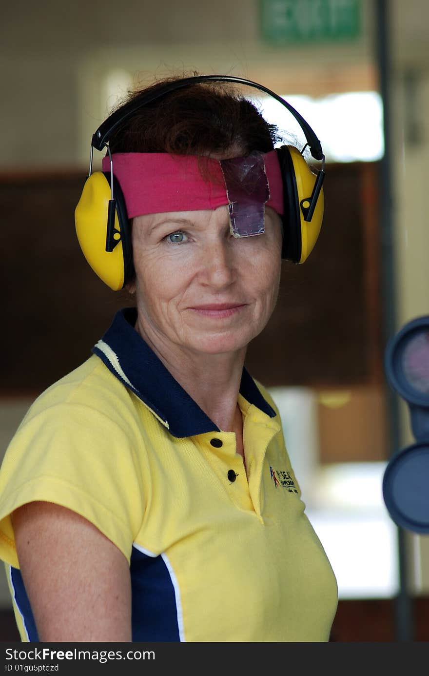 Female competitor at shooting range preparing to shoot