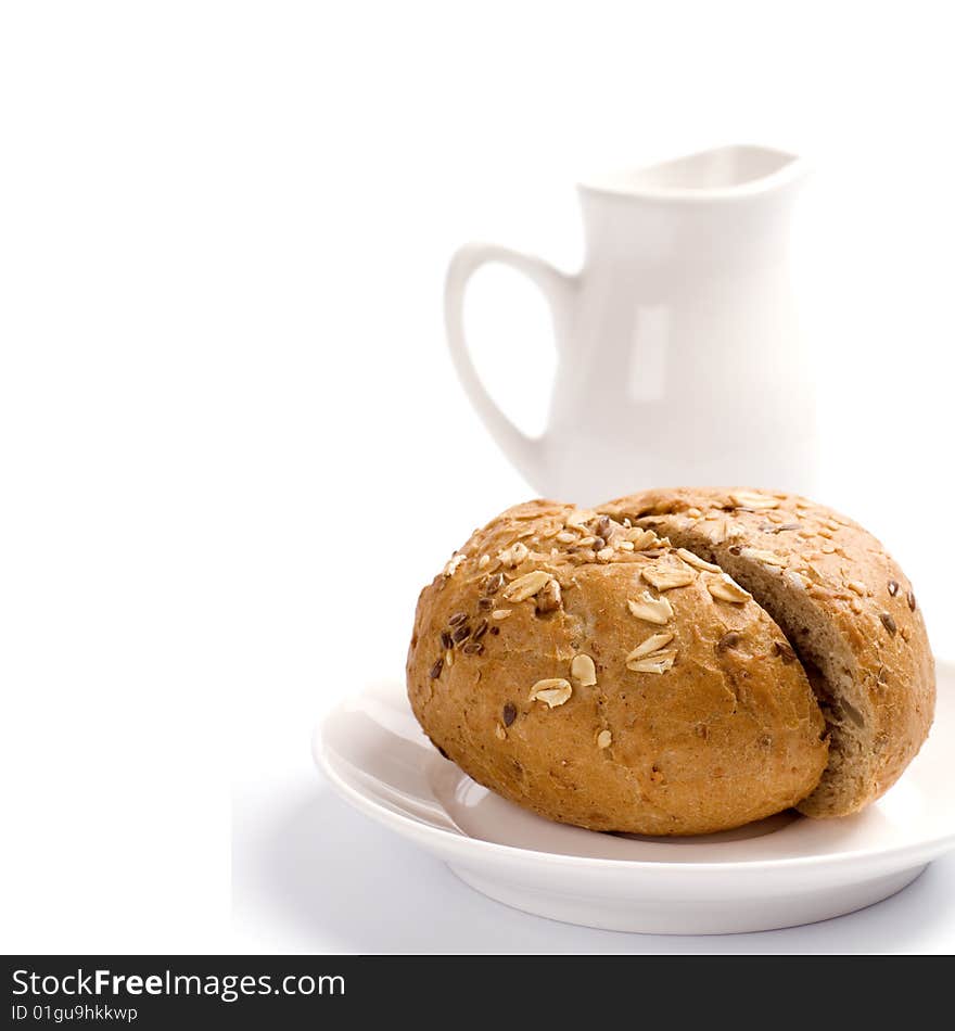 Bread and jug of milk on white background