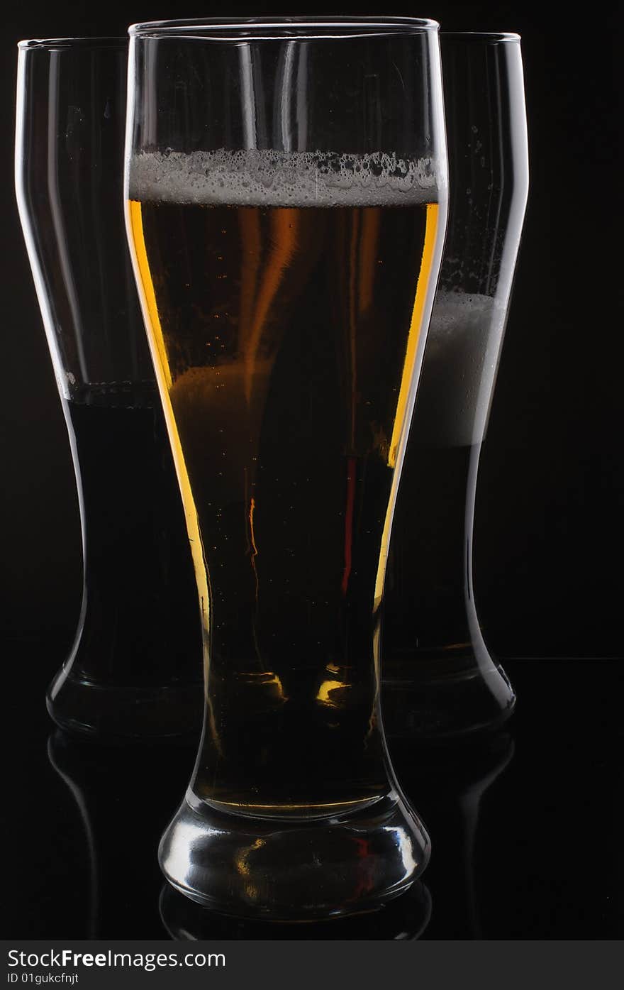 Three glasses with light and dark beer