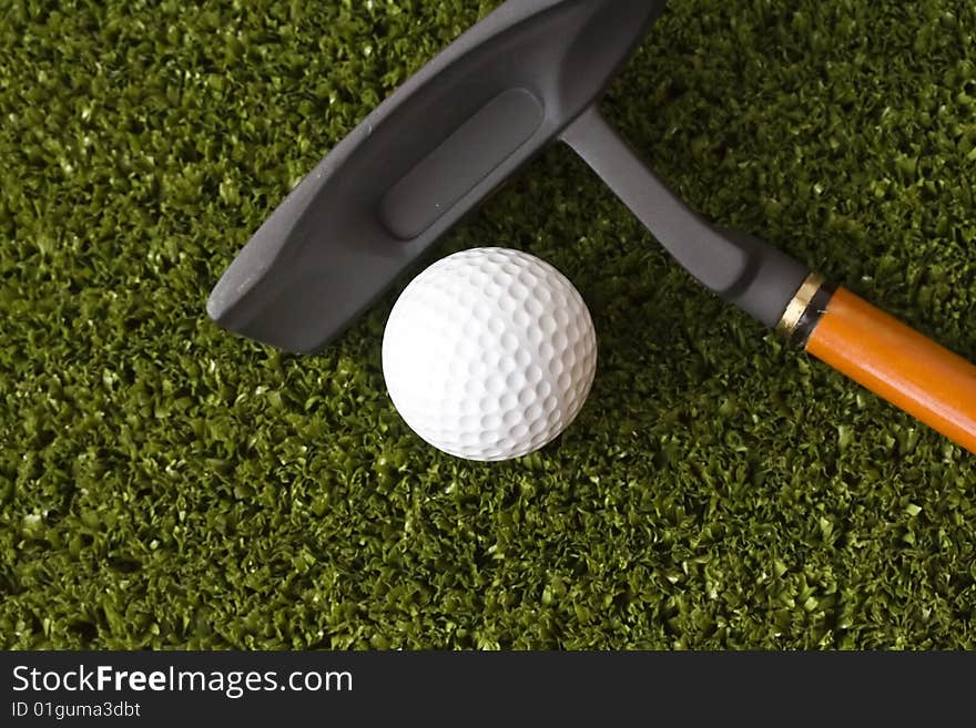 Golf ball and stick on the grass