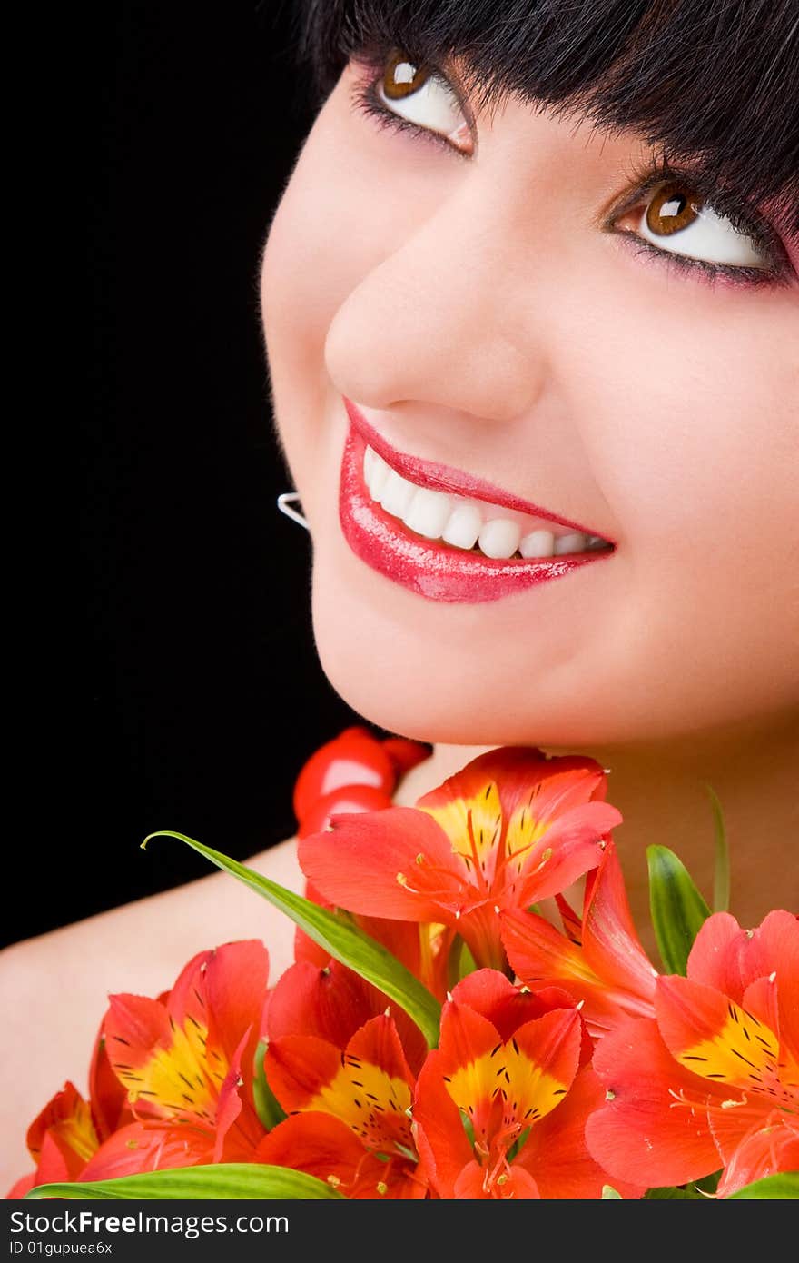 Young woman with flowers on black background