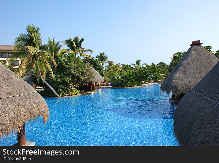 Huts on water, coast of the southern sea, tropical beach with palm trees, Sanya, China