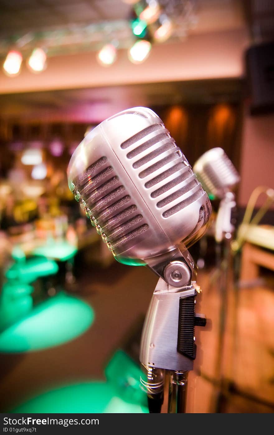 Close-up of vintage microphone, blurred club interior on background