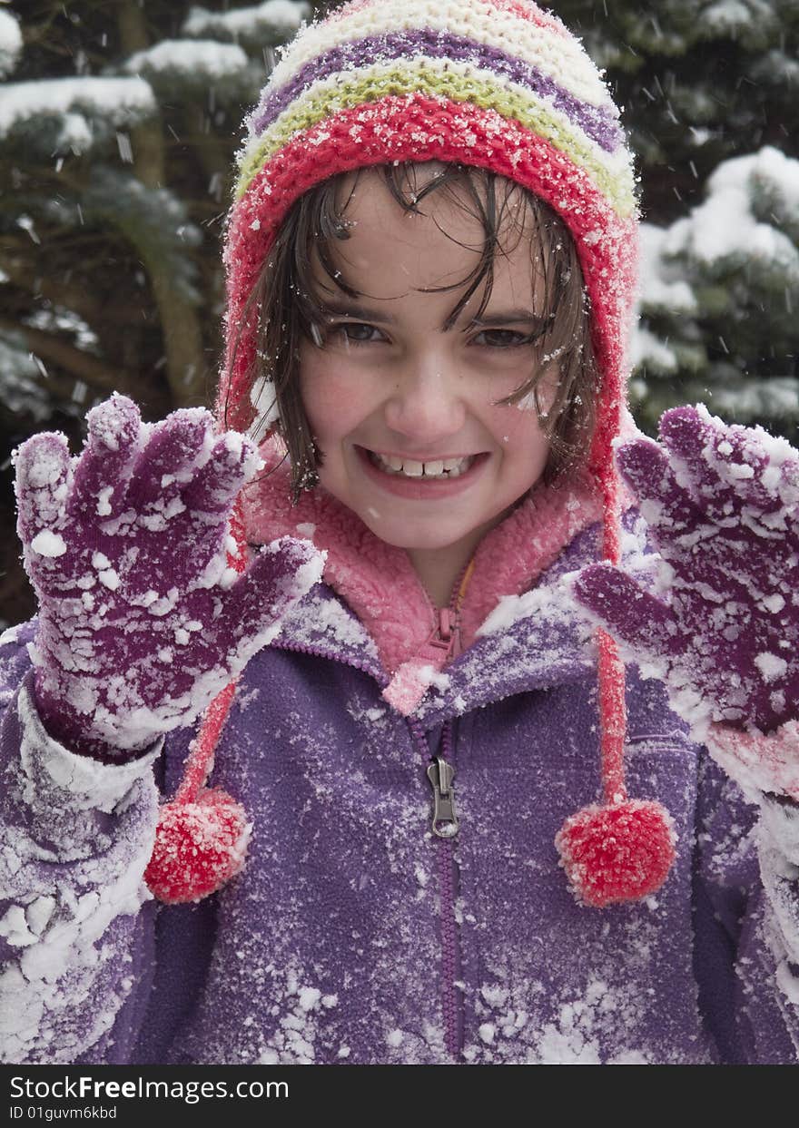 Young girl holding hands up while out playing in the snow. Young girl holding hands up while out playing in the snow