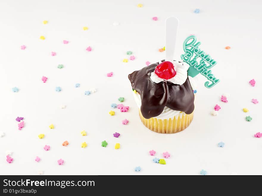 Happy Birthday Sundae Cupcake with fudge topping cherry and plastic spoon, with Happy Birthday decoration copy space