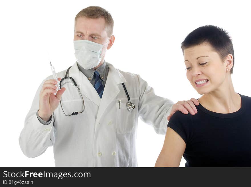 Doctor in gauze mask checks up a syringe while he holds a frightened woman by her shoulder. Doctor in gauze mask checks up a syringe while he holds a frightened woman by her shoulder