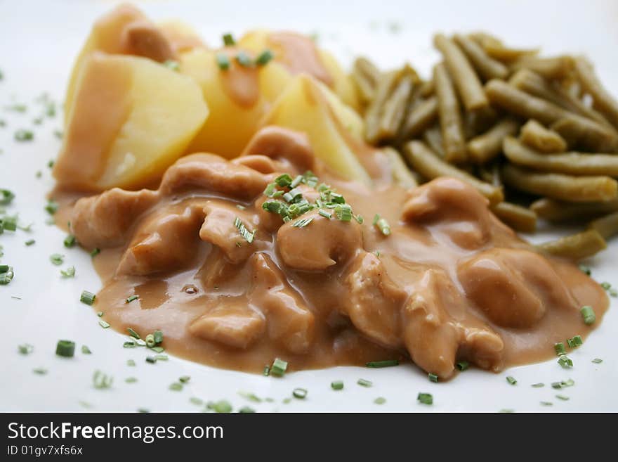 A meal of meat with potatoes and green beans