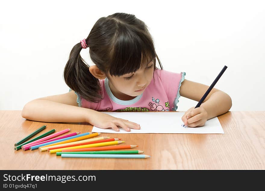 Little girl painting with color pencils