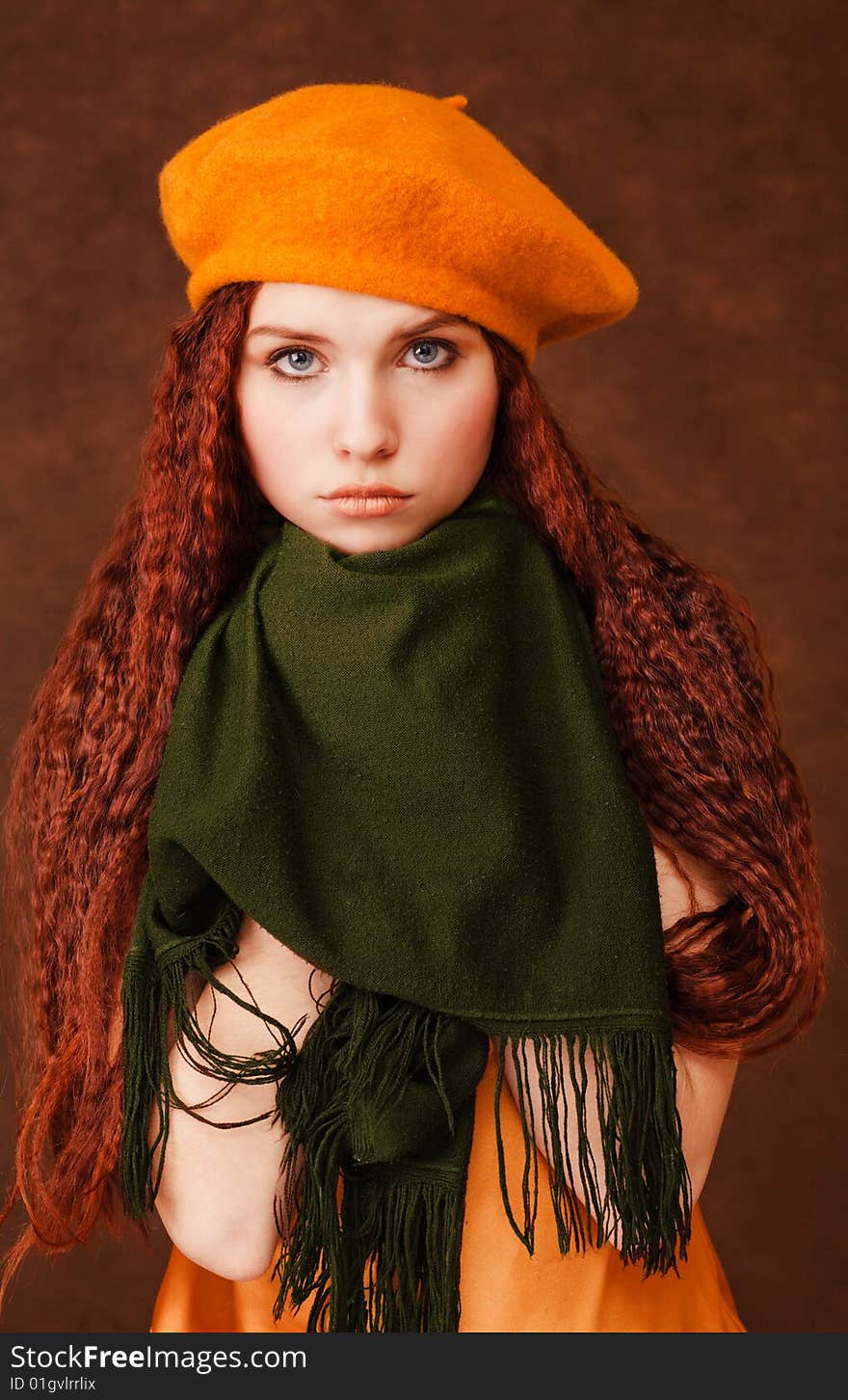 Young beautiful girl in orange beret on dark background. Young beautiful girl in orange beret on dark background