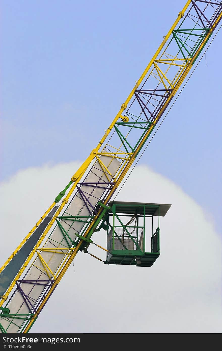 Green crane cabin on yellow structure.