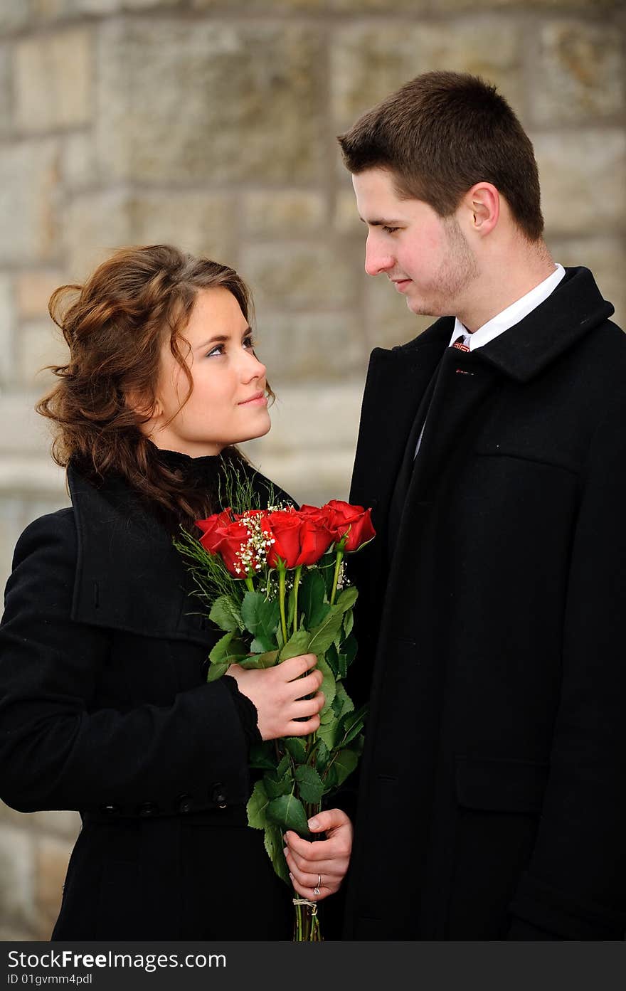 The young man gives flowers to the young woman. The young man gives flowers to the young woman