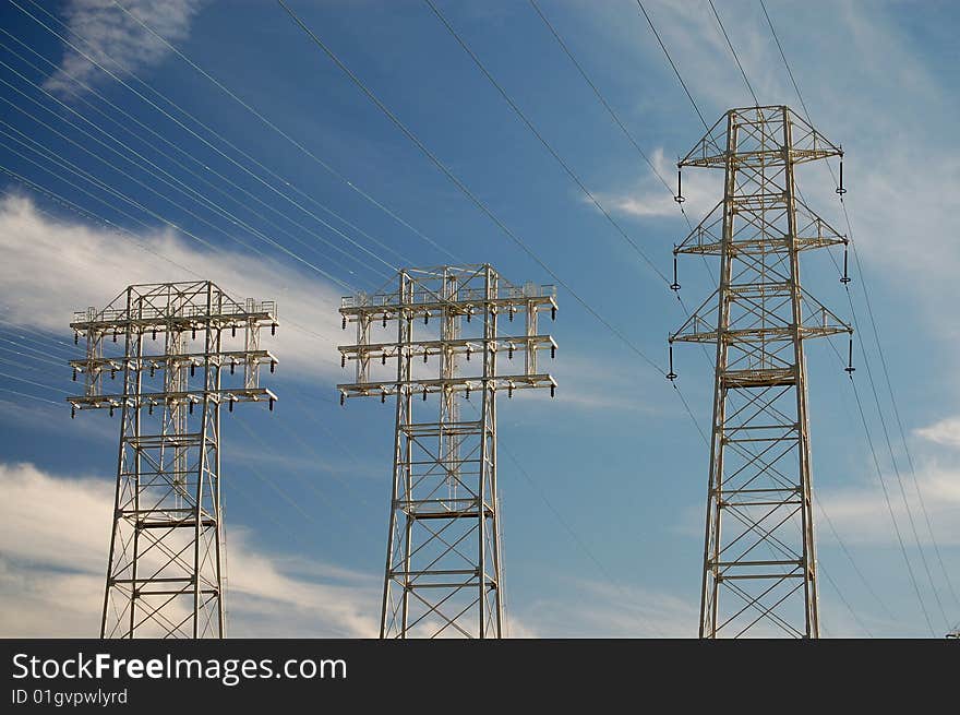 High tension power lines carry electricity to an industrial neighborhood.