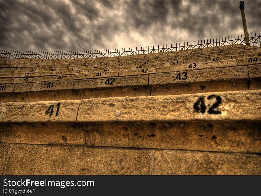 Seat numbers of an authentic ancient colosseum with cloudy dramatic sky