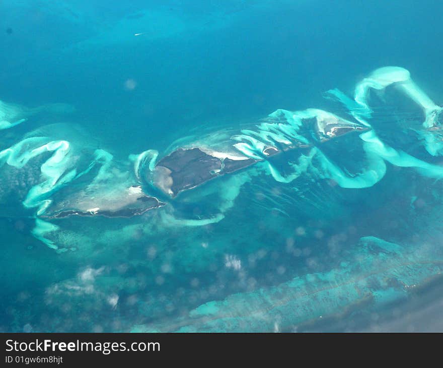 Beautiful wave formations around an island in the Caribbean Ocean. Beautiful wave formations around an island in the Caribbean Ocean