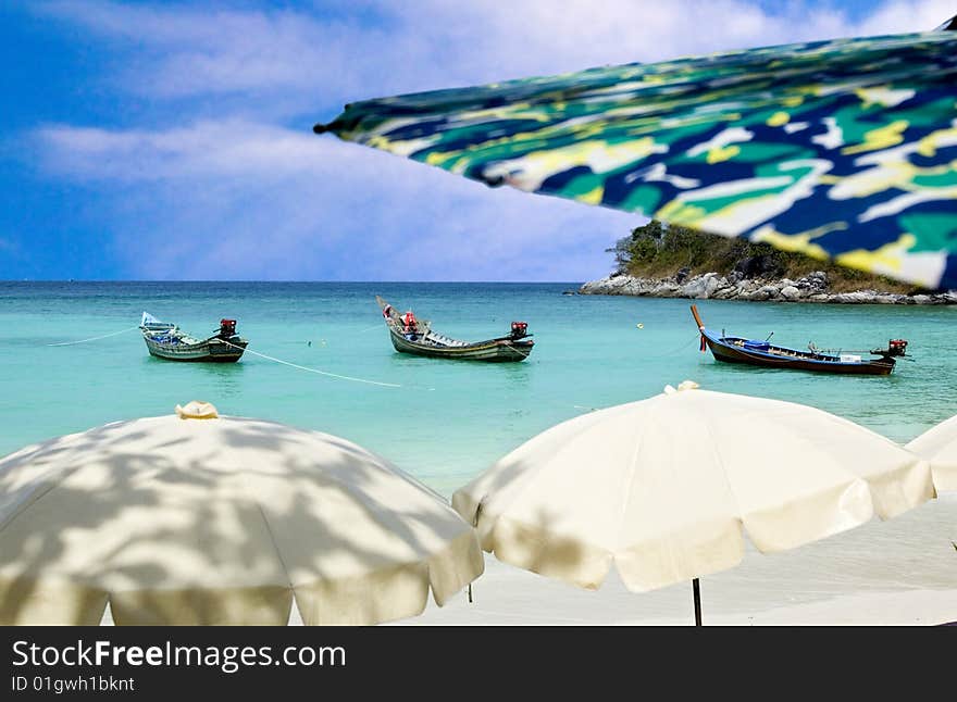 Andaman sea view with sun umbrellas and longtail boats. Andaman sea view with sun umbrellas and longtail boats