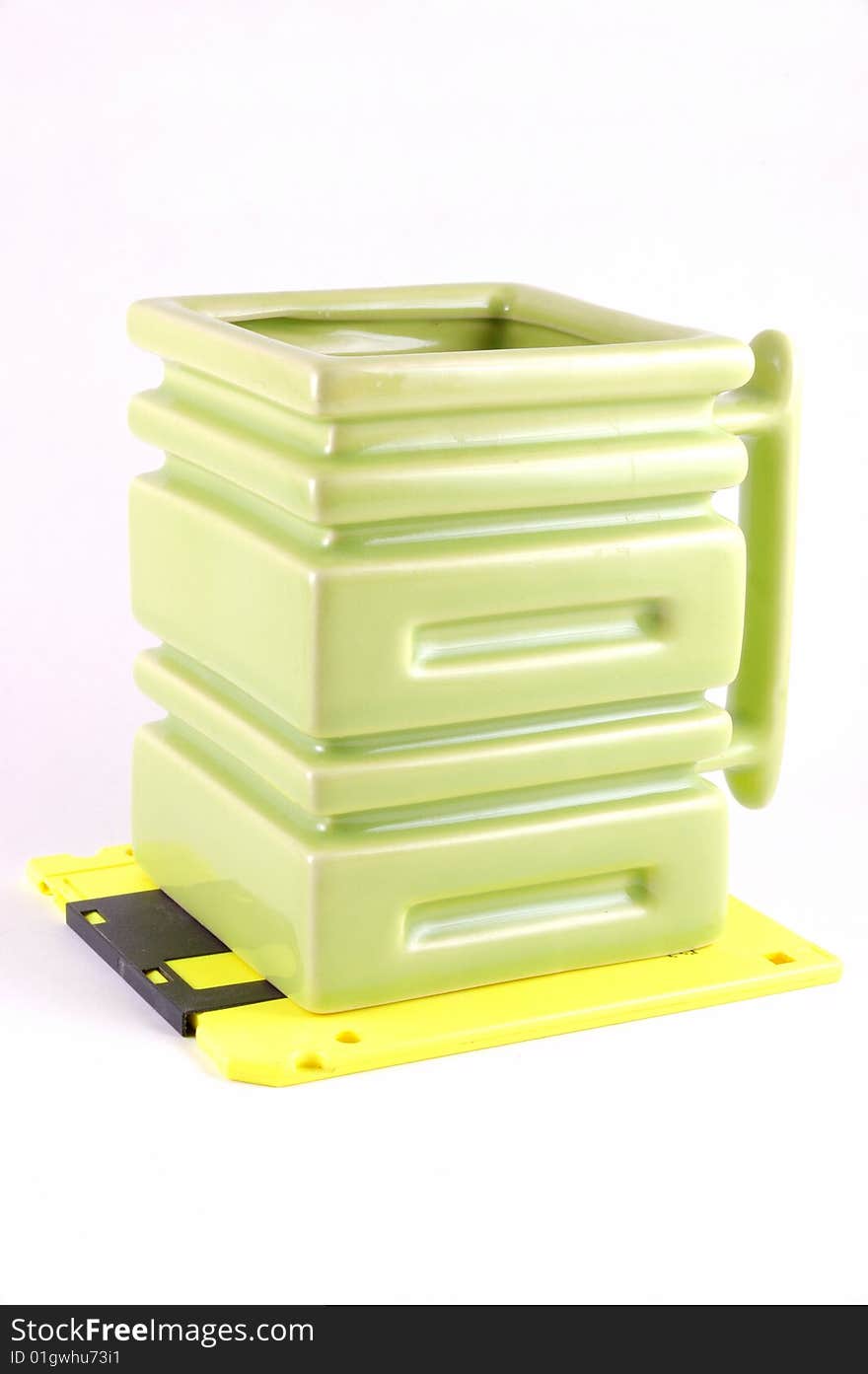 The square mug on a yellow diskette