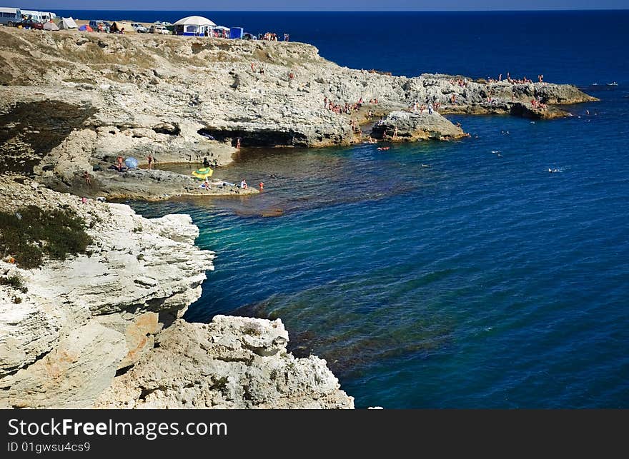 Deep blue see and diving cliffs with lot of people