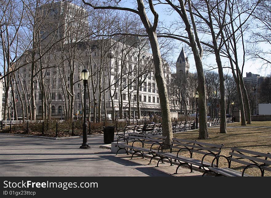 Tree lined paths in park, in downtown Brooklyn. With benches and lamps, court buildings in Background. Tree lined paths in park, in downtown Brooklyn. With benches and lamps, court buildings in Background