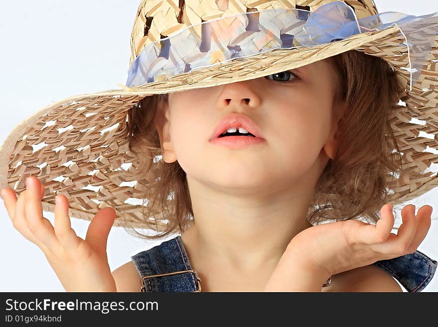 A little girl is in a straw hat. A little girl is in a straw hat.