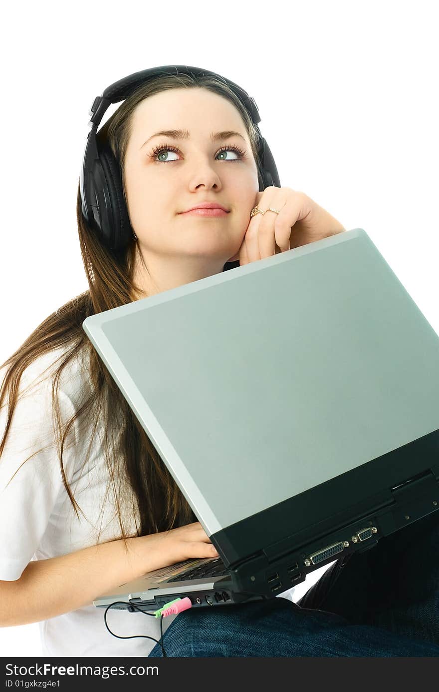 Beautiful young thoughtful woman wearing earphones with a laptop. Beautiful young thoughtful woman wearing earphones with a laptop