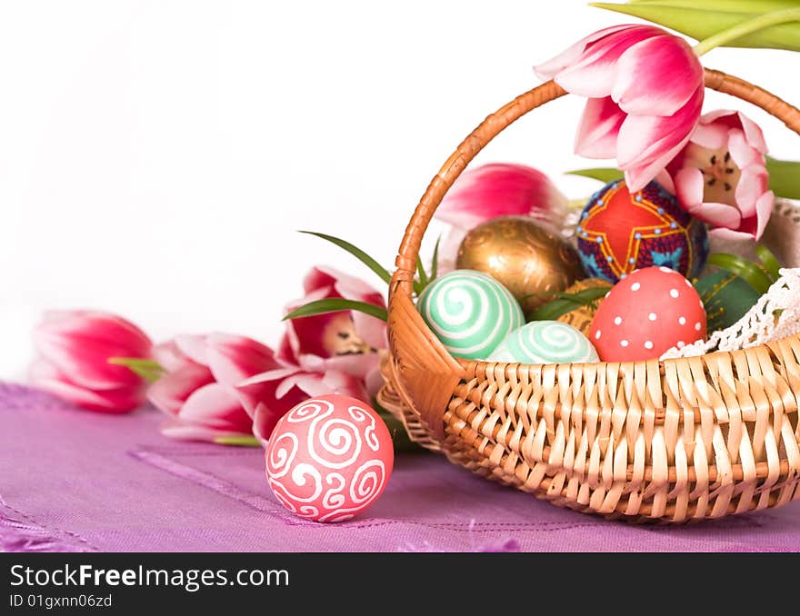 Easter colored eggs in the basket with tulips. Easter colored eggs in the basket with tulips