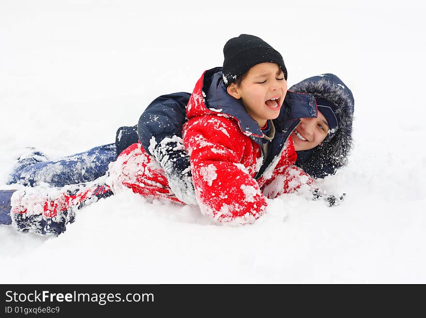 Two boys play, jump and lay down in the snow. Two boys play, jump and lay down in the snow