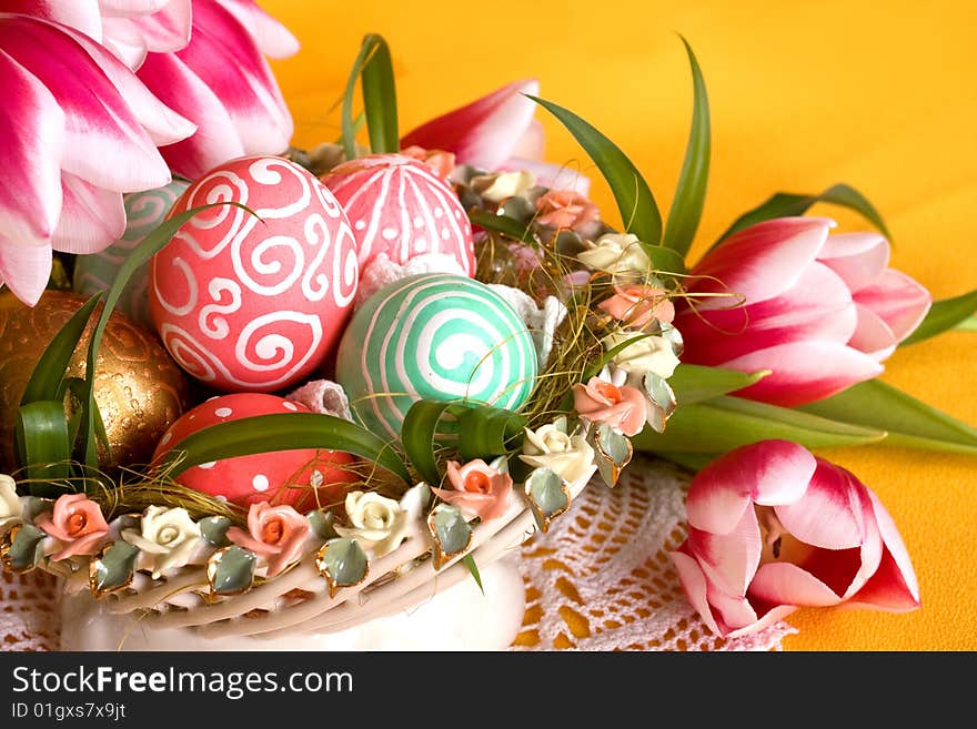 Easter colored eggs in the basket with tulips. Easter colored eggs in the basket with tulips