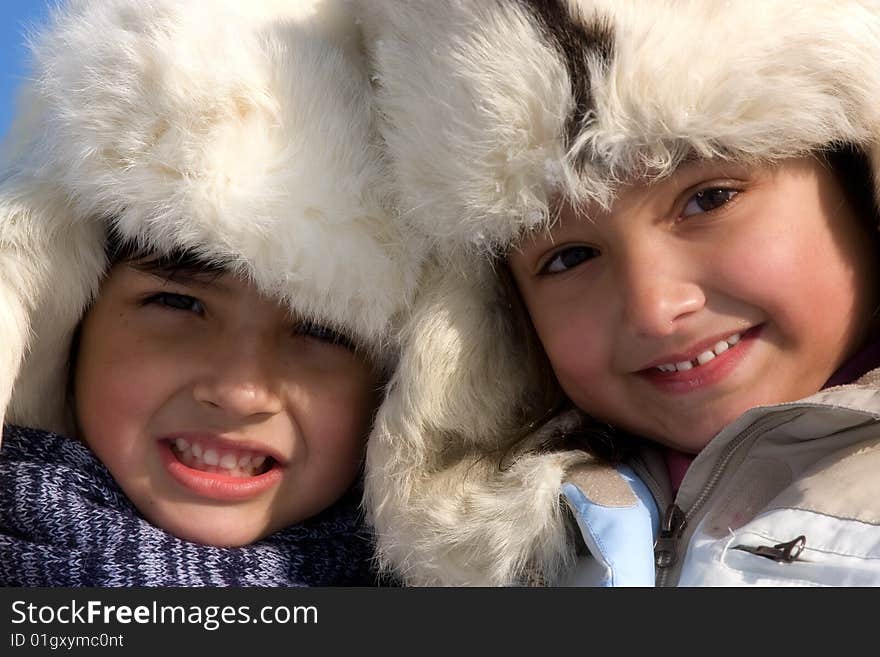 Cute girl and boy in the fur-cap in winter. Cute girl and boy in the fur-cap in winter