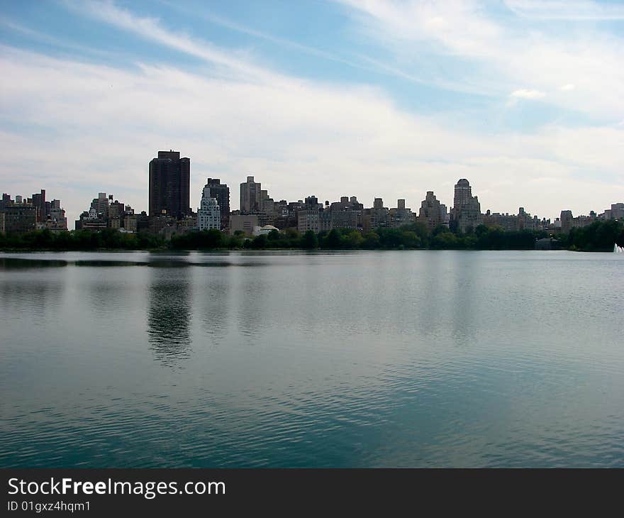 A picture of NYC over the Jacqueline Onassis Reservoir with a little reflection from the water. A picture of NYC over the Jacqueline Onassis Reservoir with a little reflection from the water.