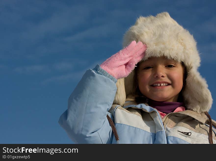 Smilling girl winter portrait in the fur-cap