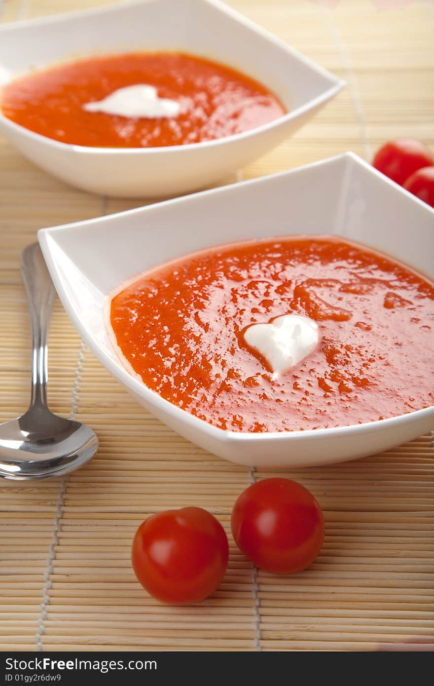 Tomato soup in white plates over bamboo mat. Tomato soup in white plates over bamboo mat