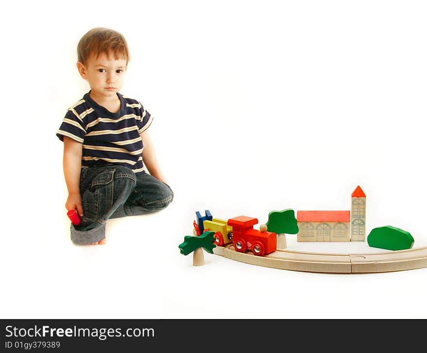 Toddler playing with wooden train over white