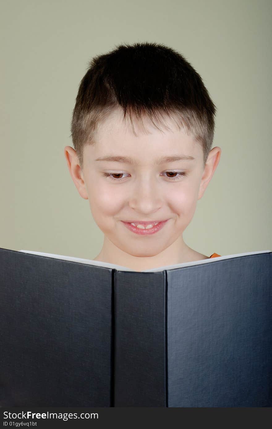 Small boy reading a big black book. Small boy reading a big black book