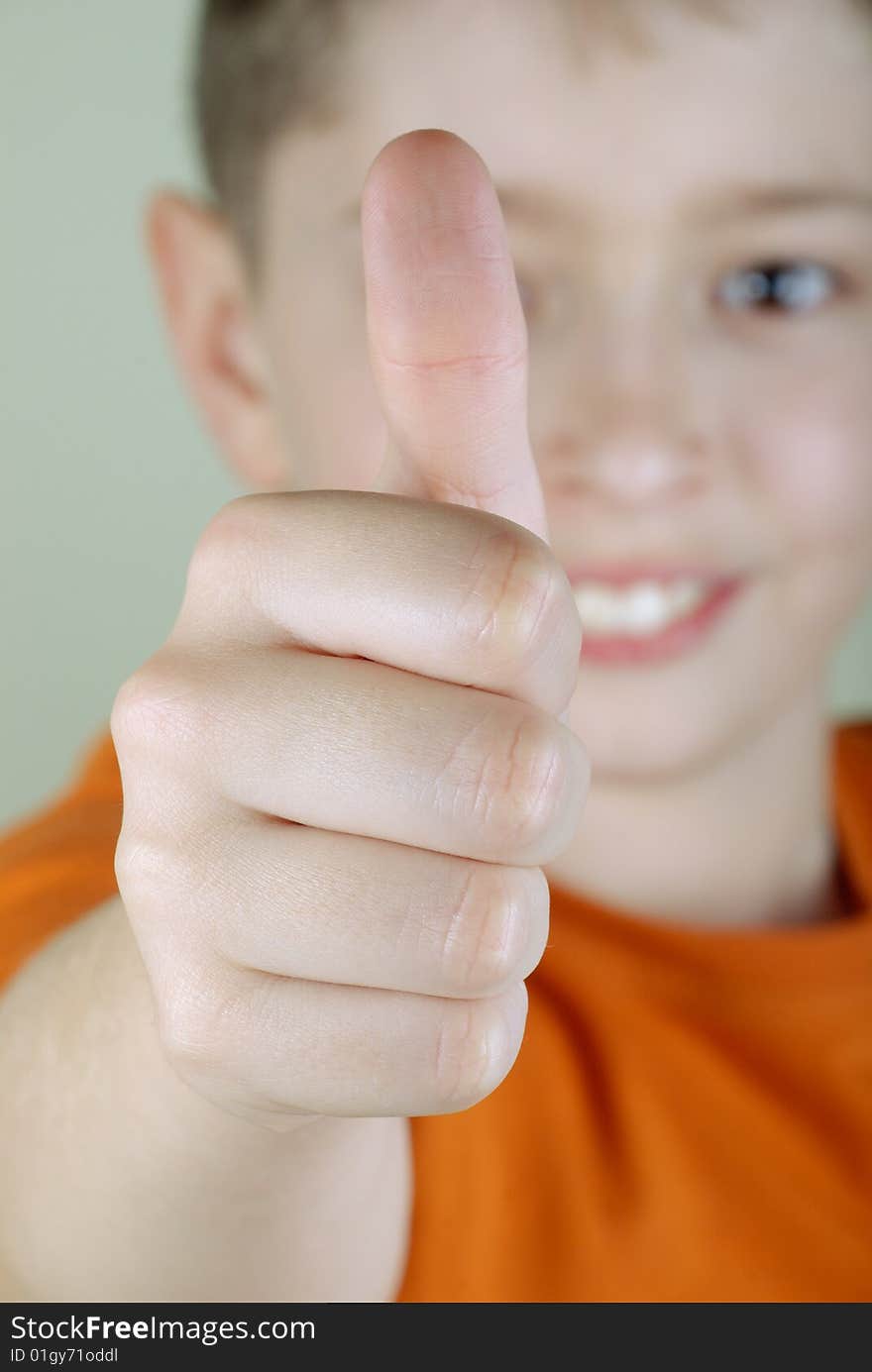 Smiling boy with thumb-up. Close-up